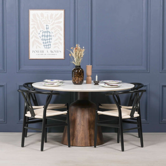 Natural marble round dining table with acacia wood base and black Scandinavian chairs in a modern dining setting.