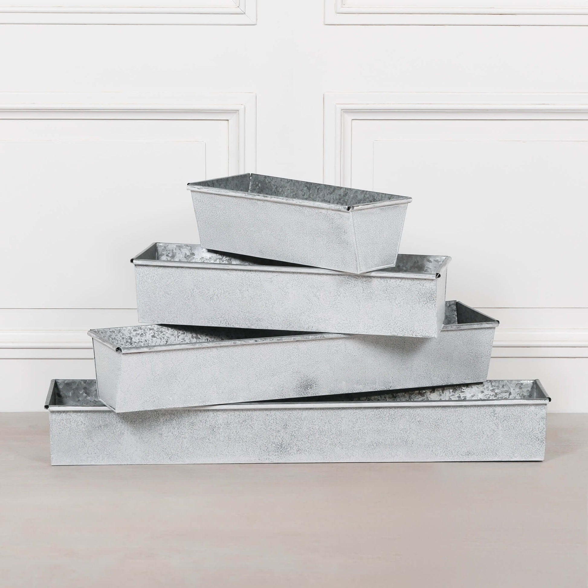 Stack of white wash metal window box planters showcasing rustic metal design for outdoor gardening.