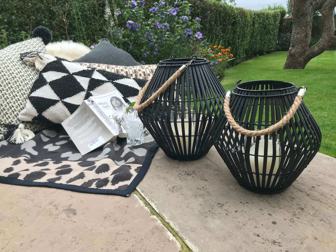 Get Your Garden Ready For Summer with stylish lanterns, cozy pillows, and a beautiful garden setting.