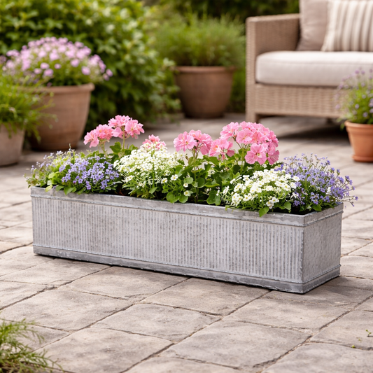 Floral planter box on a patio with outdoor furniture in the background