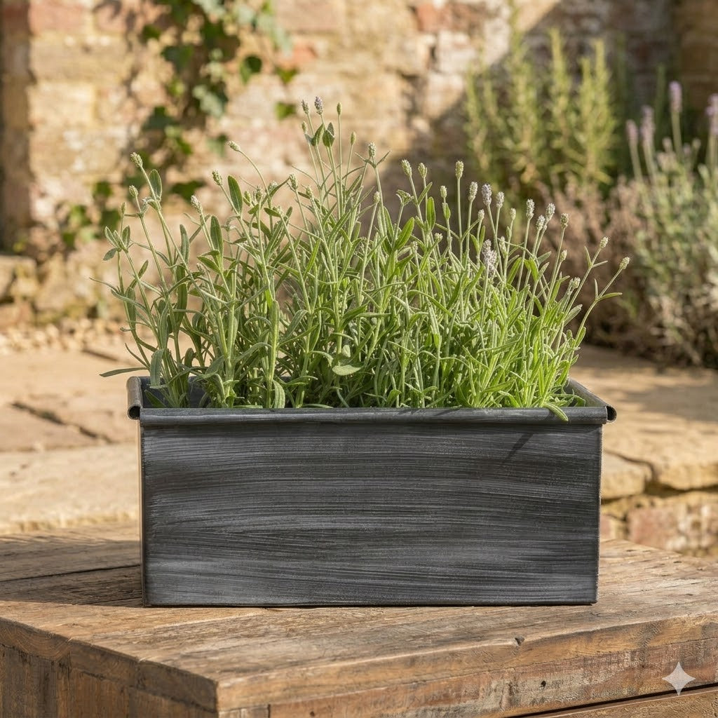 Rectangular wooden planter with green plants on a wooden surface outdoors.