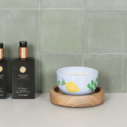 Round 15cm Wooden Tray with a colorful candle bowl and stylish bottles on a tiled countertop.