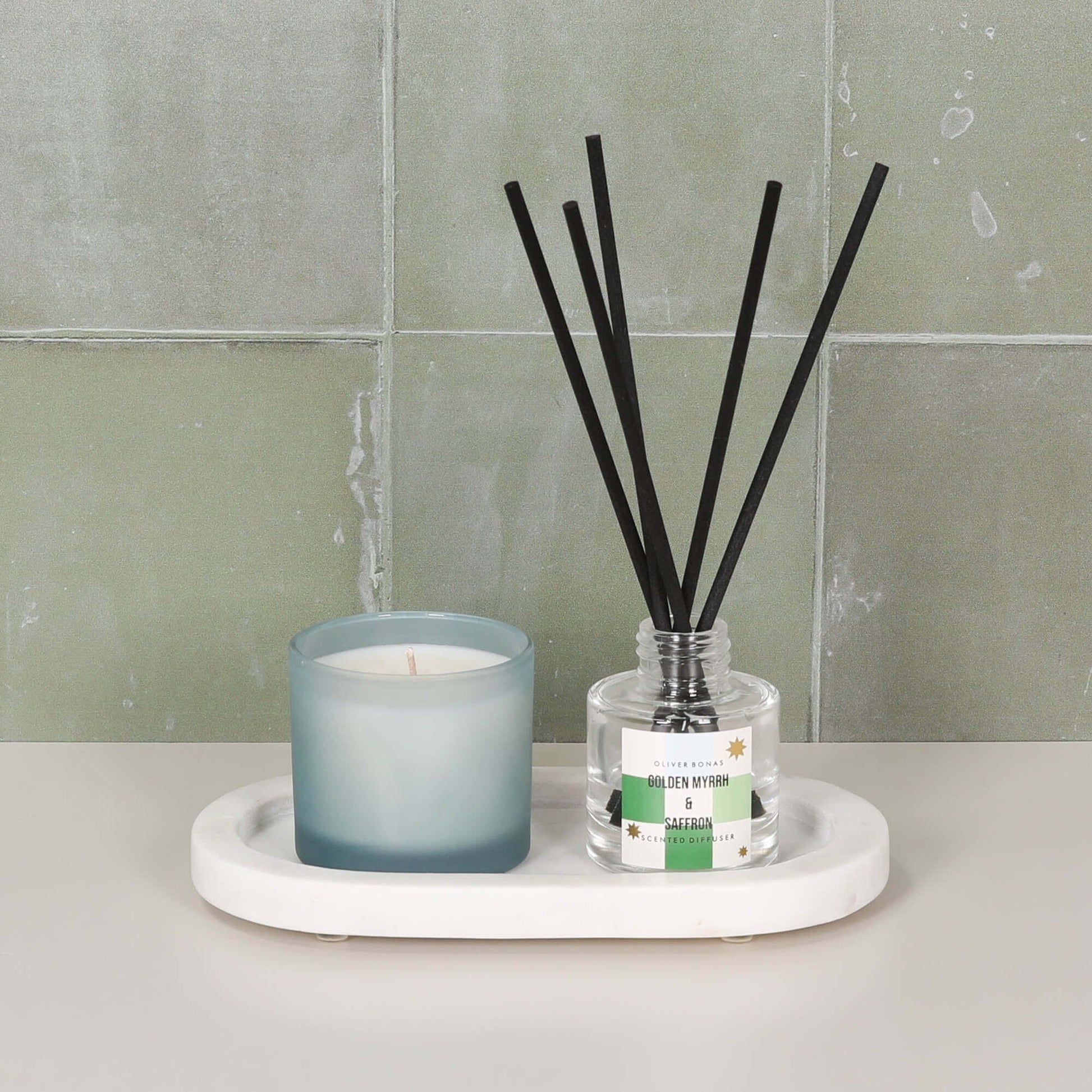White Marble Long Oval 20cm Tray holding a candle and diffuser on a stylish countertop.