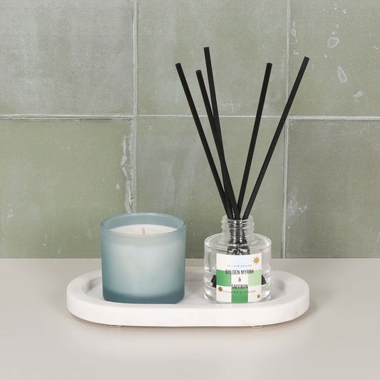 White Marble Long Oval 20cm Tray holding a candle and diffuser on a stylish countertop.
