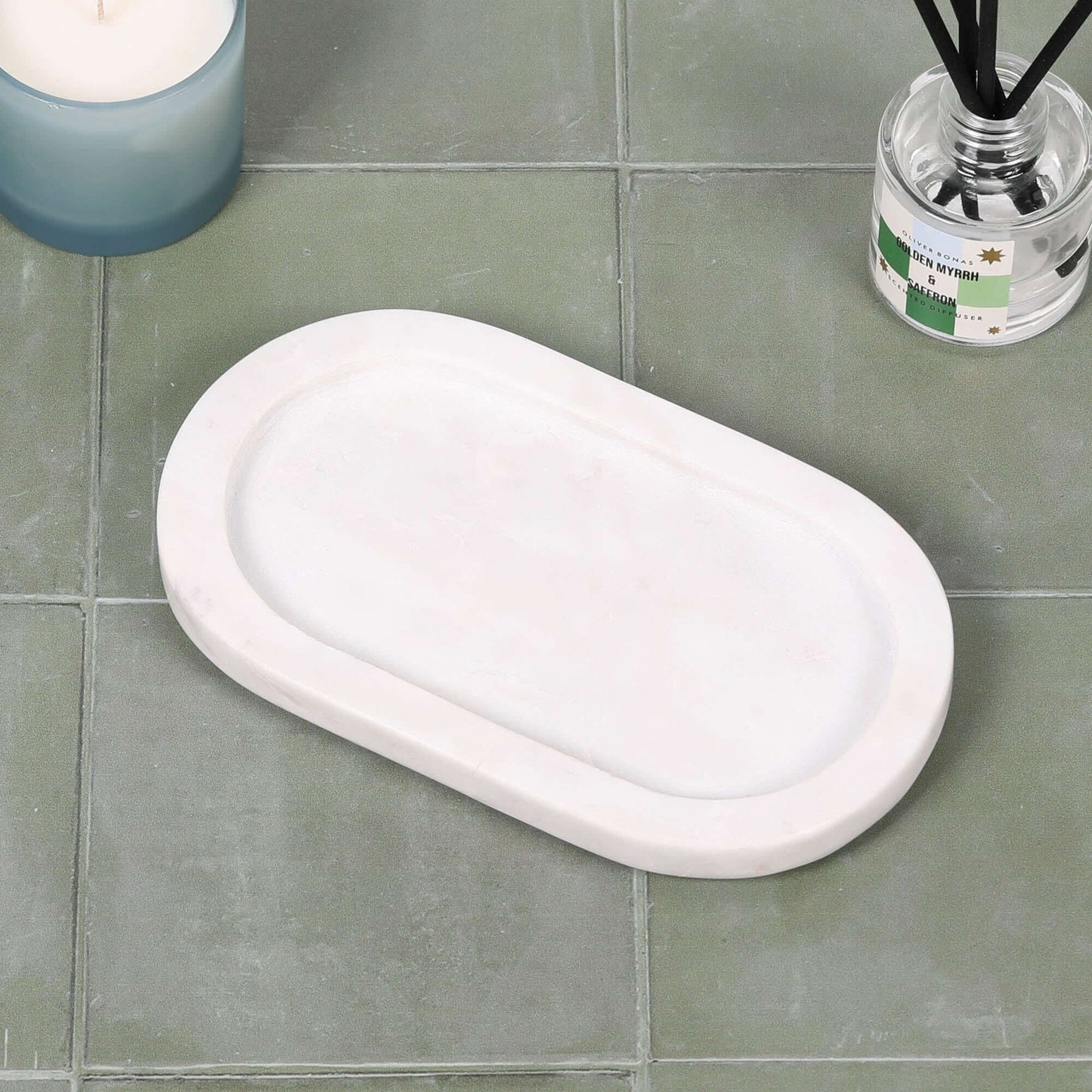 White Marble Long Oval 20cm Tray on green tiles, showcasing its elegant design and smooth surface.
