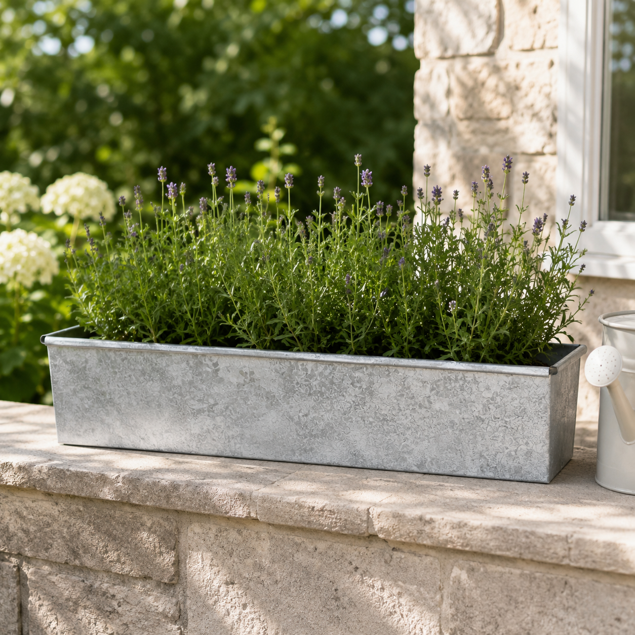 Metal planter with green plants on a stone ledge outdoors