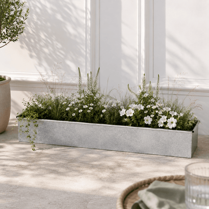 Decorative planter with greenery and white flowers on a patio