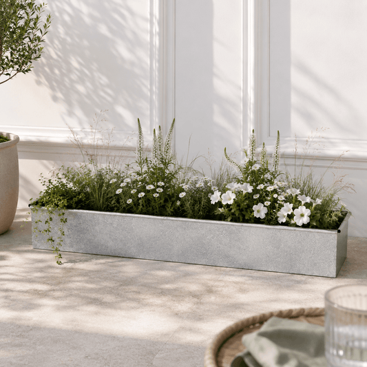 Decorative planter with greenery and white flowers on a patio