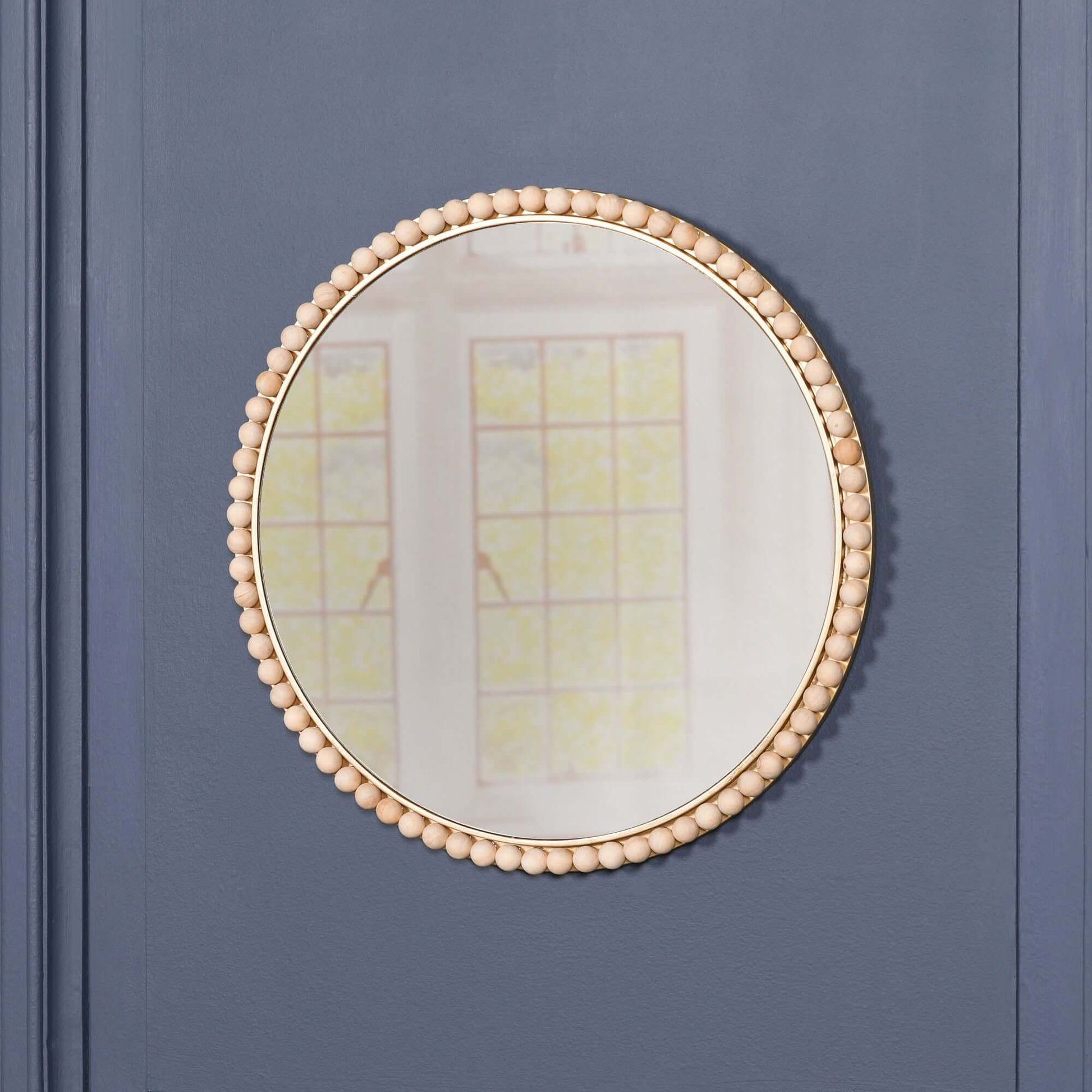 Wooden Bobble Round Wall Mirror with wooden beads and glass, dimension H50 x W50 x D3cm on a blue wall