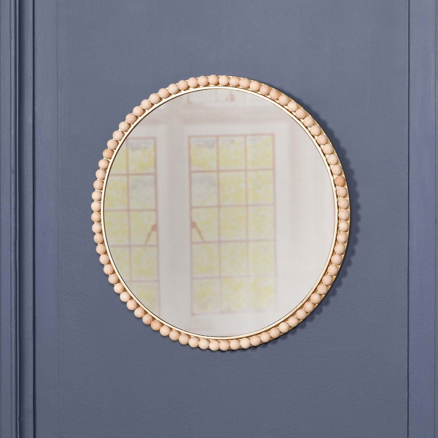 Wooden Bobble Round Wall Mirror with wooden beads and glass, dimension H50 x W50 x D3cm on a blue wall